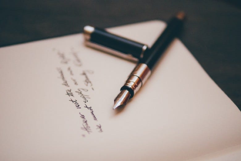 Two pens on a paper of poetry