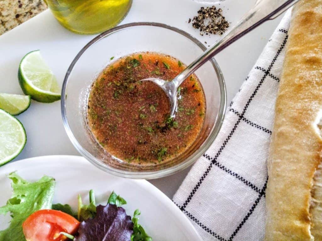 tomato lime dressing in bowl with loaf of bread