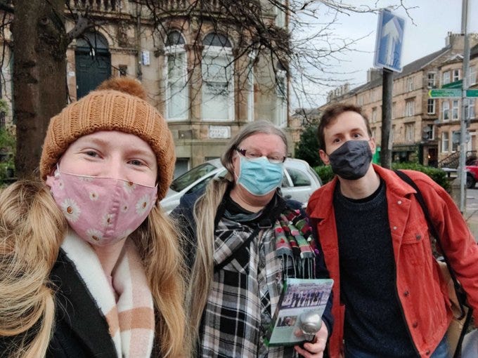 Ellie, Elaine and Niall masked and wrapped up warmly outside a home in Govanhill