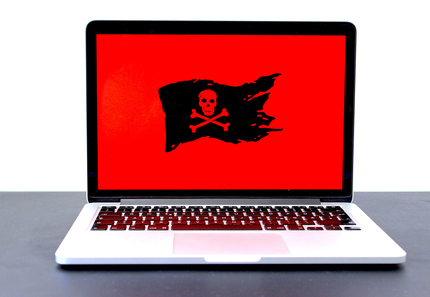 Photo of a laptop whose background is red with a black pirate flag. (Michael Geiger / Unsplash)