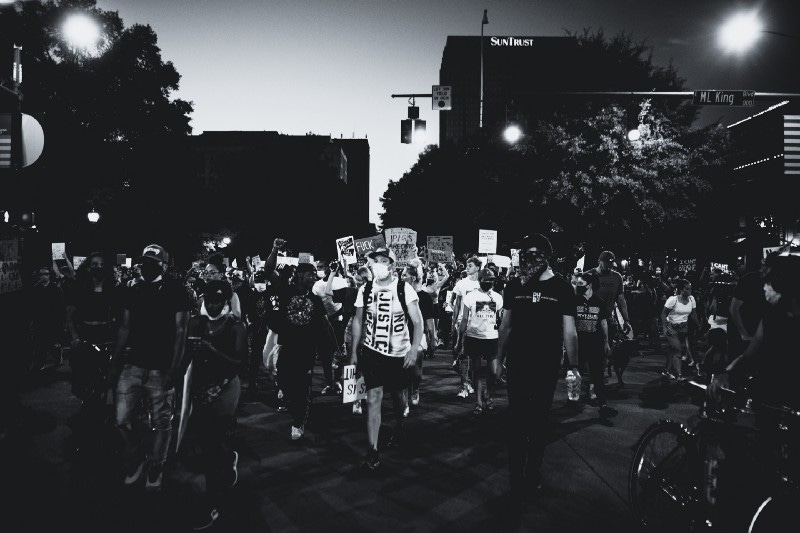 A black and white photo of a protest. SurvivingTomorrow.org