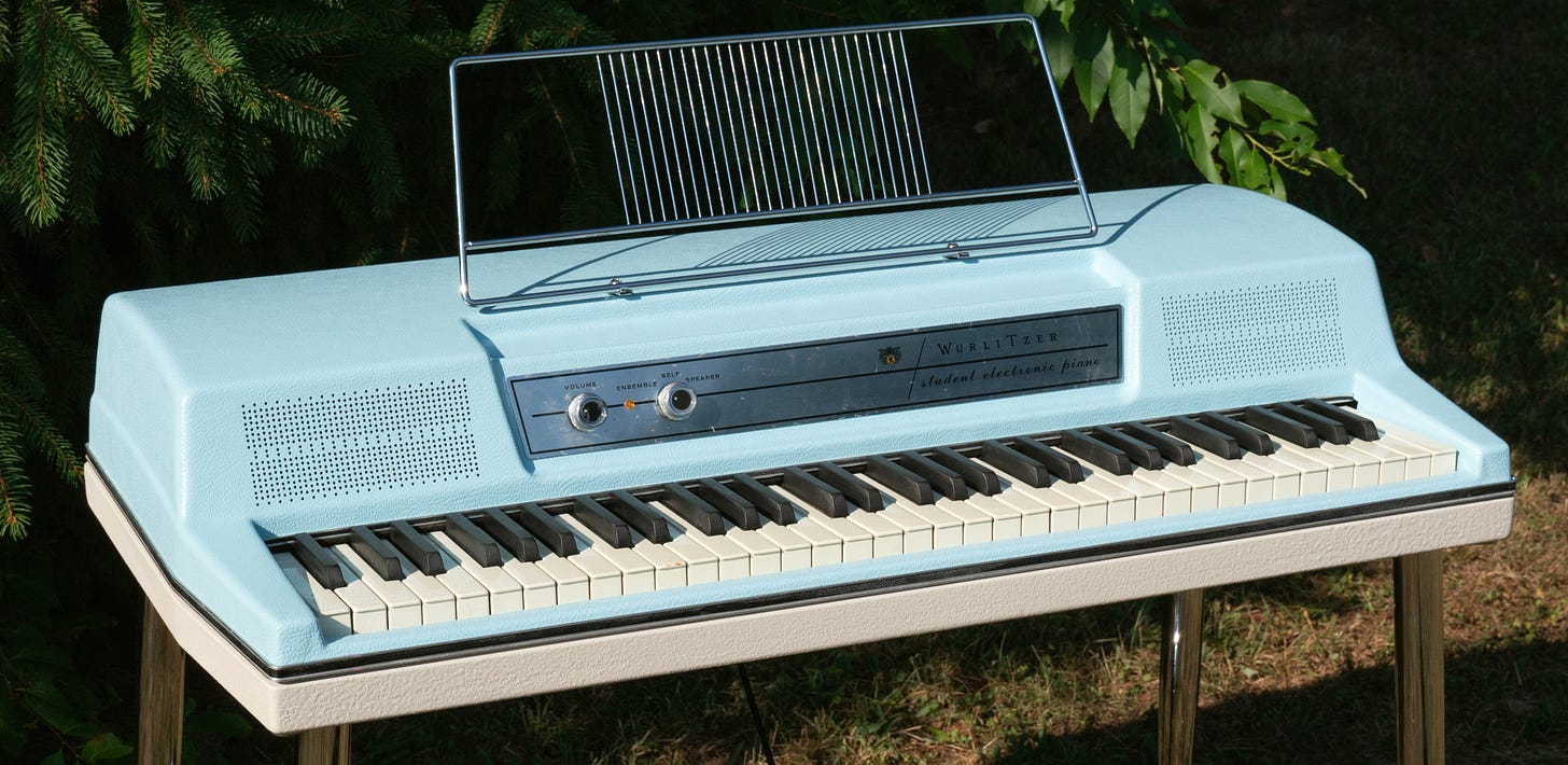 Wurlitzer 200 with a lid that has been painted pale baby blue and a base that has been painted a cream color.