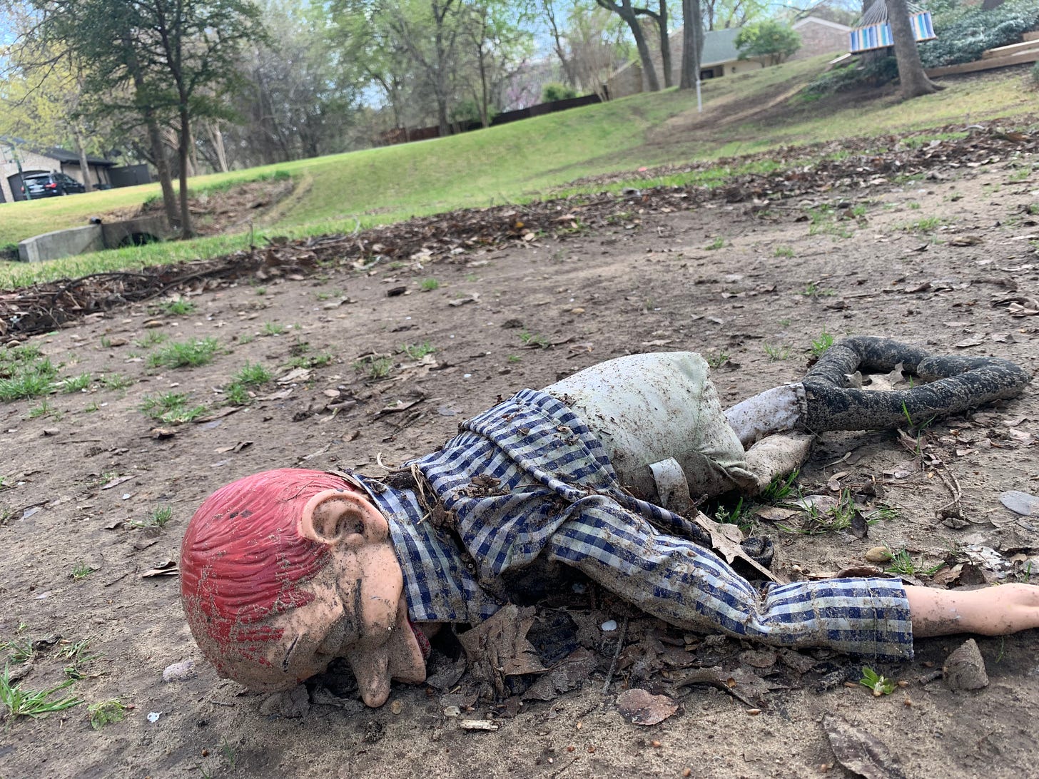 A ventriloquist's dummy laying face down in a creek bed
