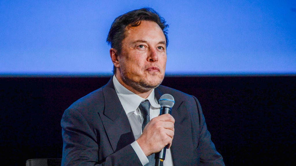Elon musk holding a microphone