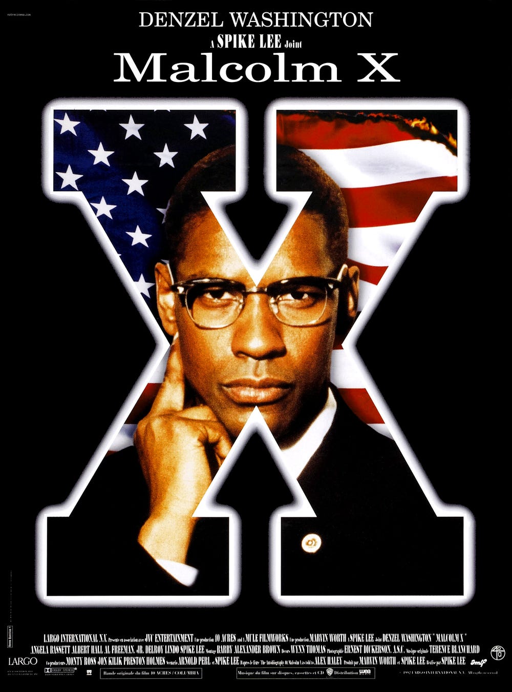 This image shows the one-sheet poster for Spike Lee's 1992 film Malcolm X. Over a black background is seen a large X. Inside this block letter is a photo of Denzel Washington as Malcolm X overlaying an American flag. This image shows the one-sheet poster for Spike Lee's 1992 film Malcolm X. Over a black background is seen a large X. Inside this block letter is a photo of Denzel Washington as Malcolm X overlaying an American flag.