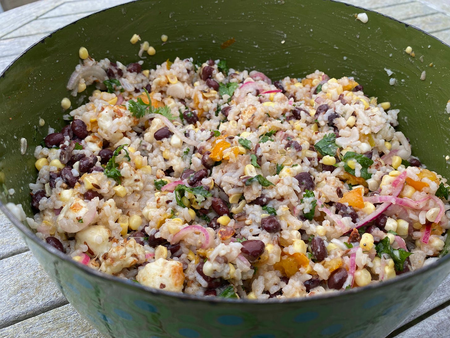 A large green bowl of rice and black bean salad.
