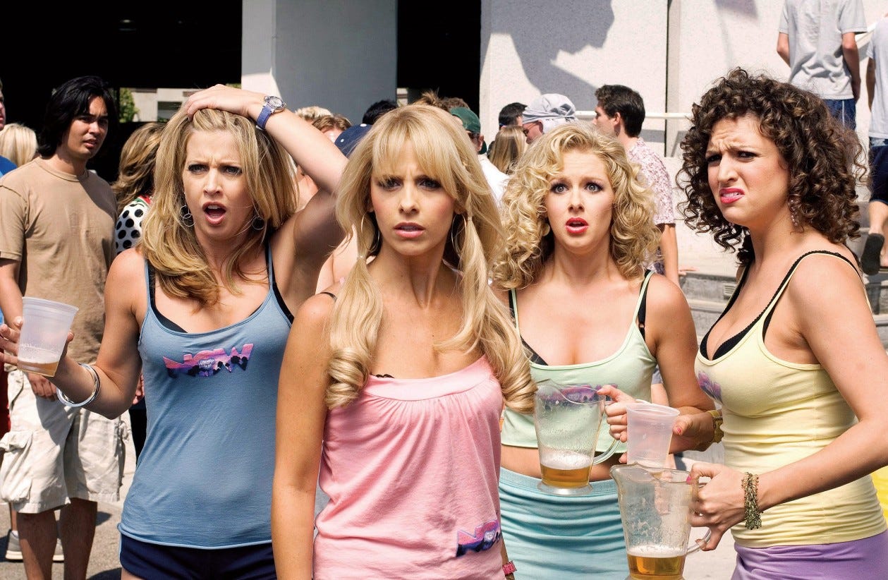 Movie still from Southland Tales. Four California girls look in shock, holding beer cups at an outdoor party.