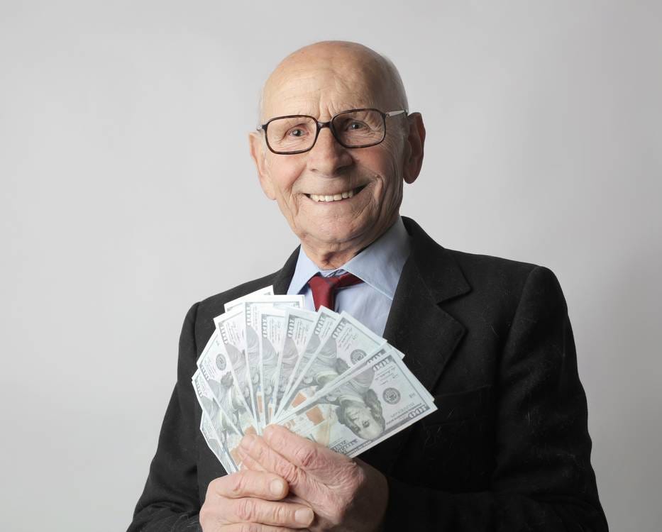 Man In Black Suit Holding Dollar Bills