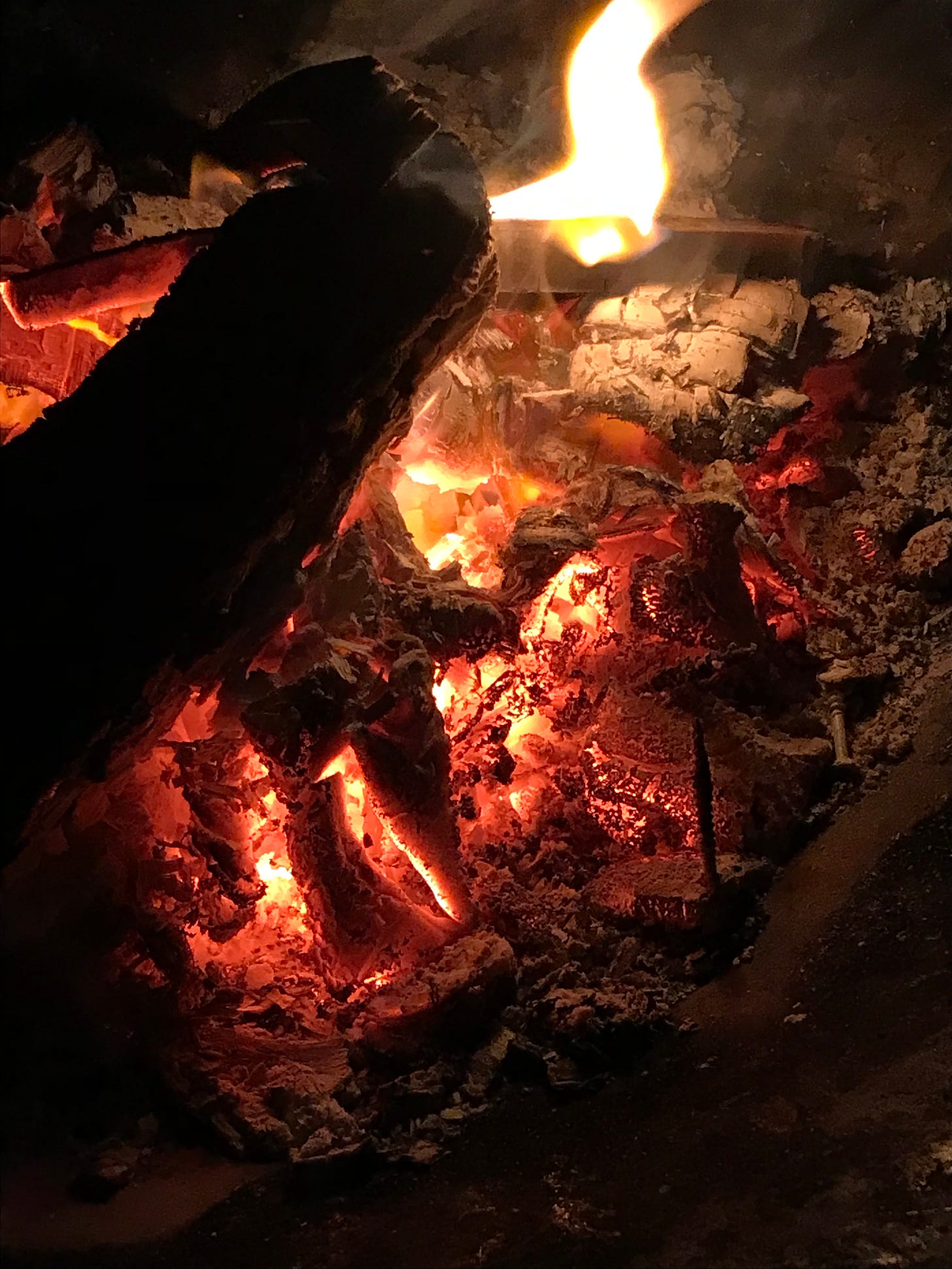 a picture of glowing embers with a flame