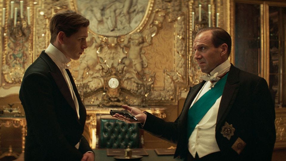 The Duke of Oxford hands Conrad a small gun. Both are in fancy dinner-attire at the Tsar's palace.