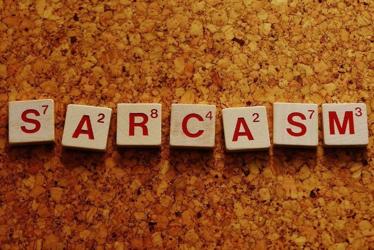 This shows the word Sarcasm written in scrabble tiles