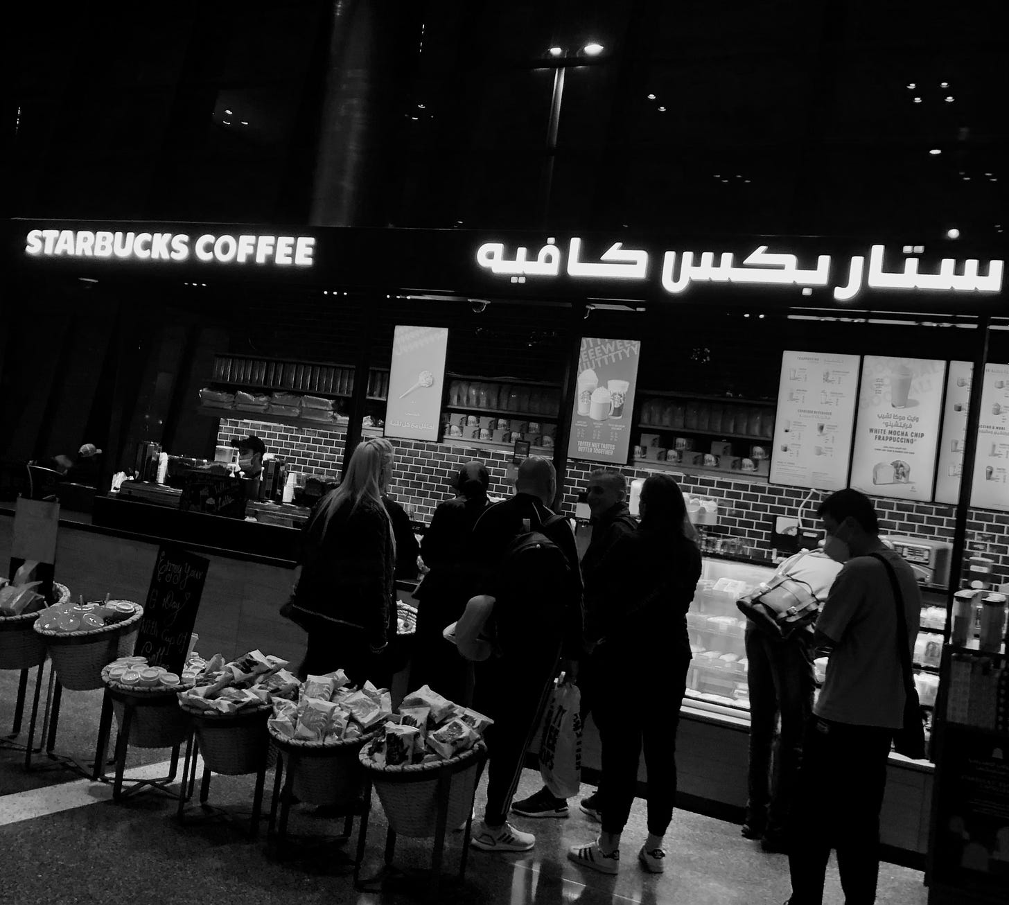black-and-white photo of a Starbucks with Arabic script in the store sign