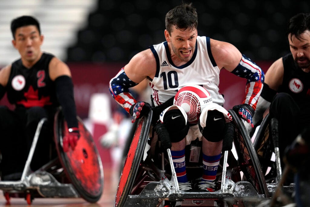 Joshua Wheeler, of the United States, carries a ball against Canada’s defense during a pool phase group match of wheelchair rugby at the Tokyo 2020 Paralympic Games, Thursday, Aug. 26, 2021, in Tokyo, Japan. 