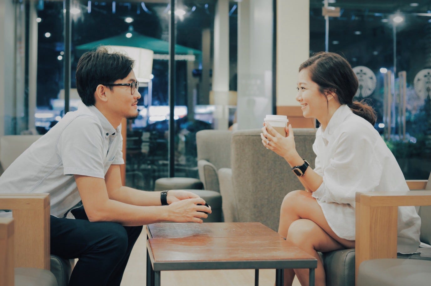 A young couple chat together in a coffee shop on their first date.