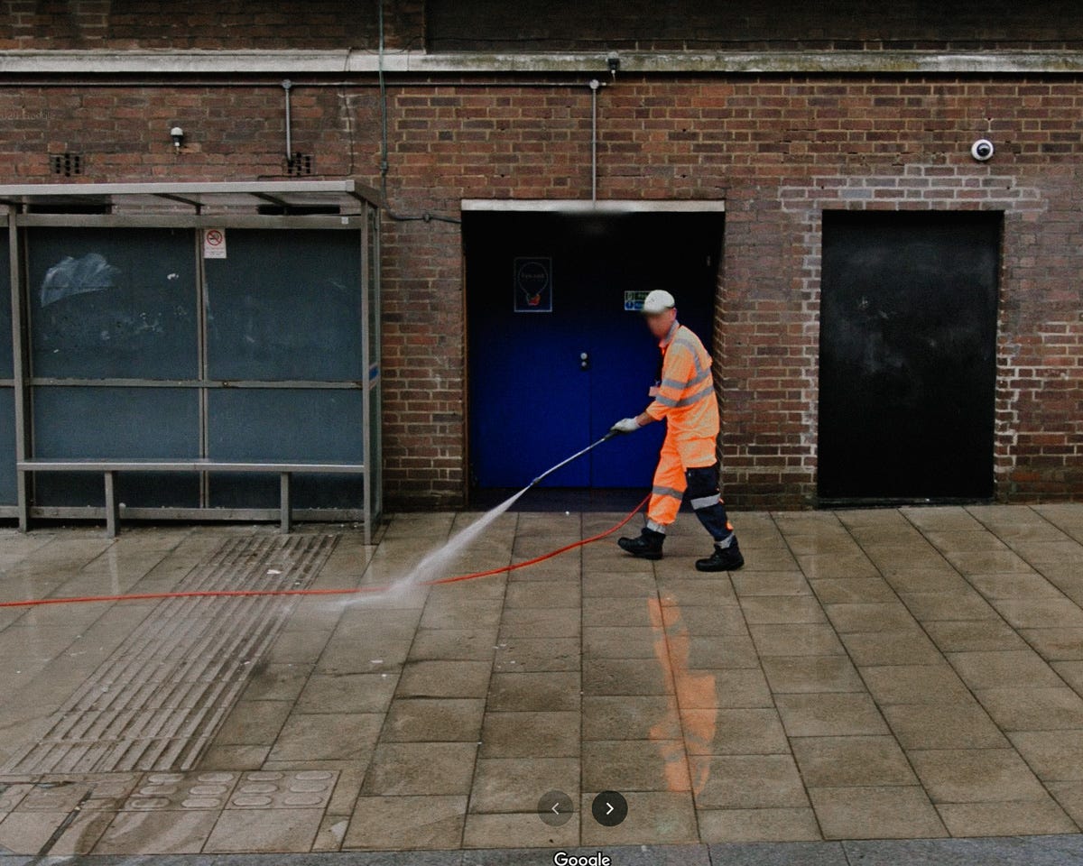 Google Maps image of a worker washing the road