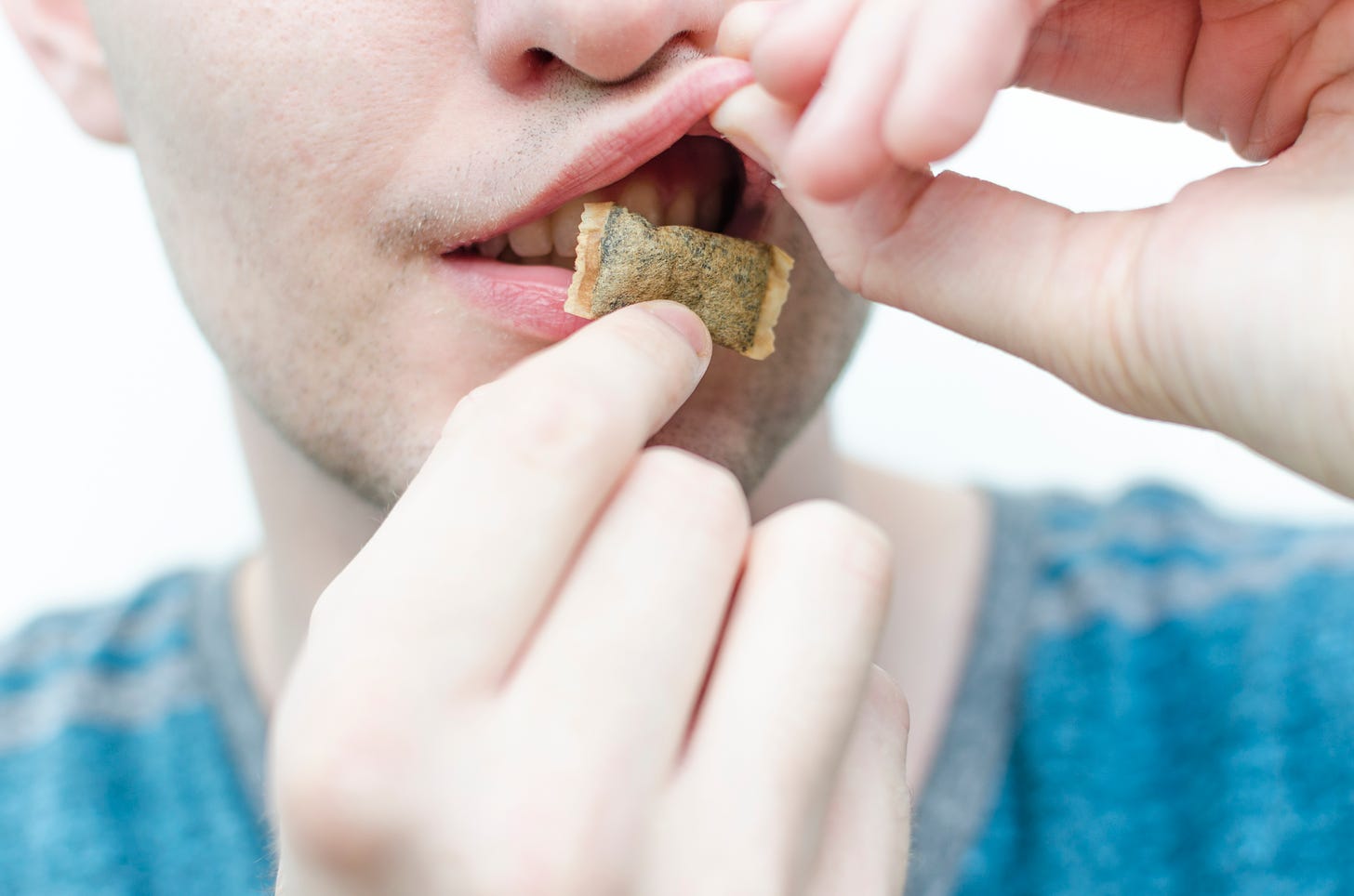 Teen boy putting a tobacco pouch in his mouth