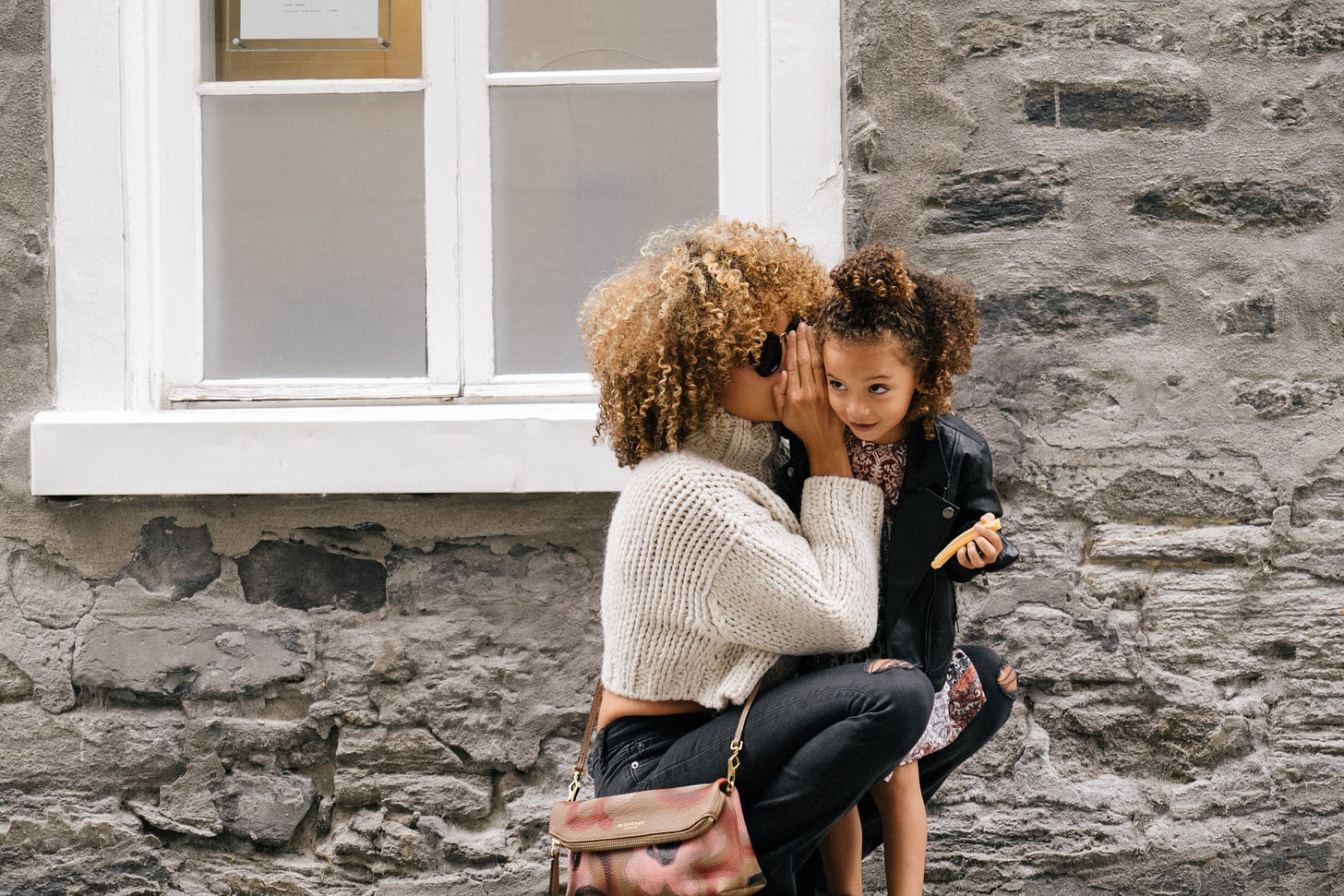 woman wearing white sweater carrying a daughter photo