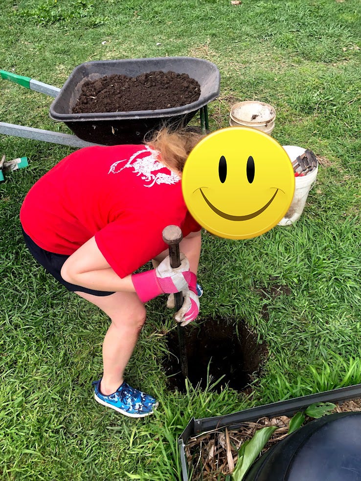 Young woman digging hole.