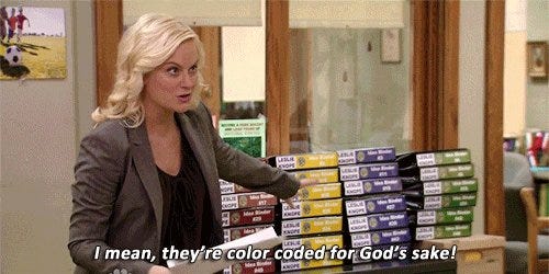 Leslie Knope pointing to her color coded planning binders.