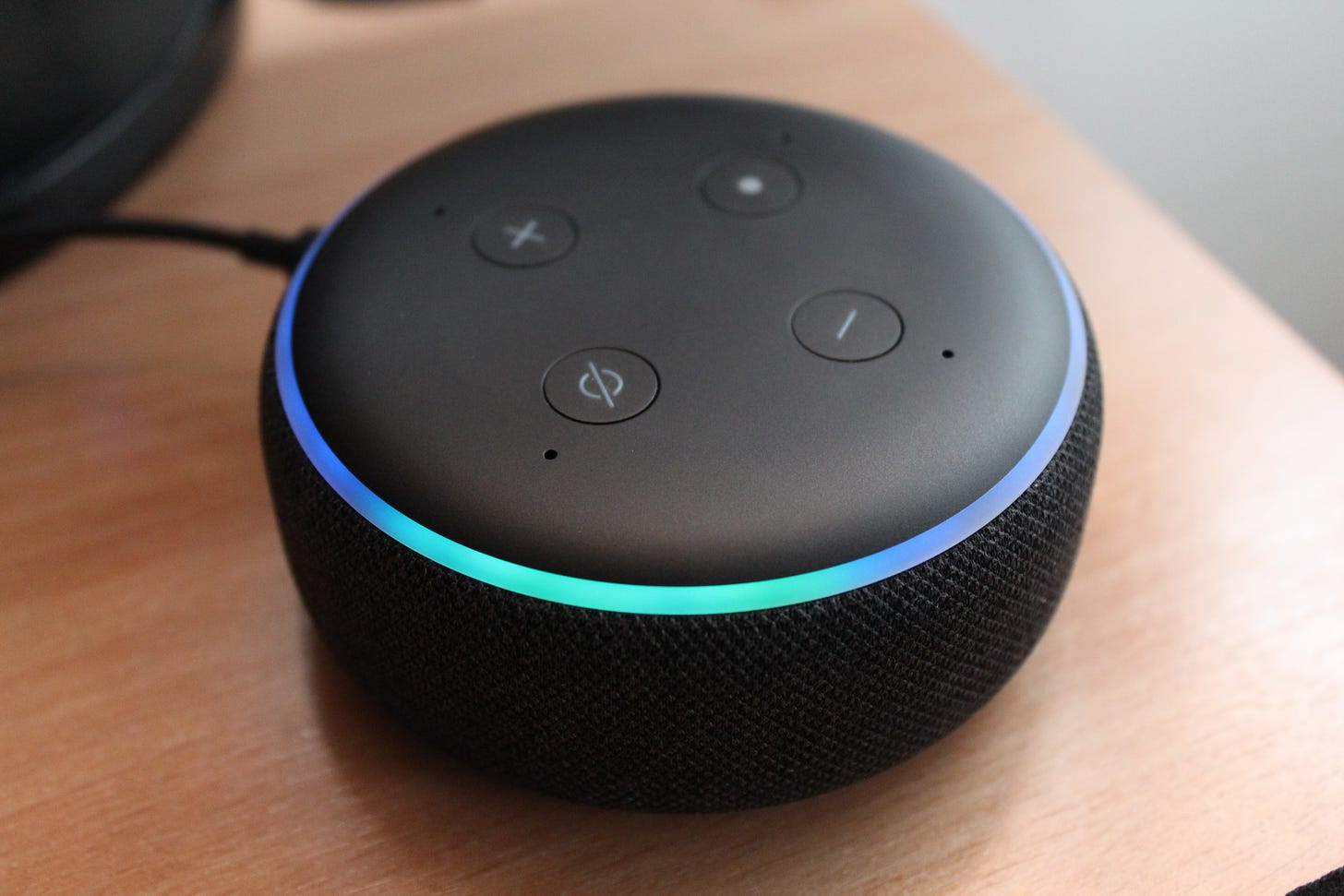 black Amazon Echo Dot on wood tabletop