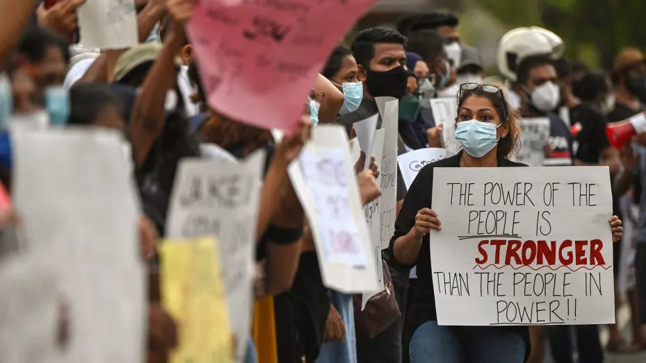 Protestors hold banners and placards during a demonstration against the surge in prices and shortage of fuel and other essential commodities in Colombo on April 2, 2022.