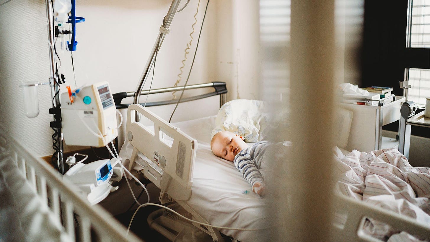 A photo of a baby boy laying in a hospital bed.