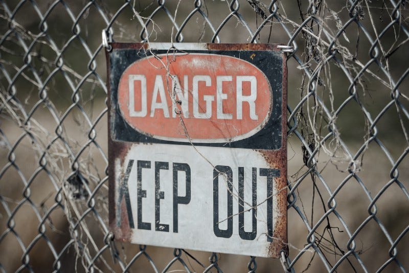A sign on a fence: Danger Keep Out