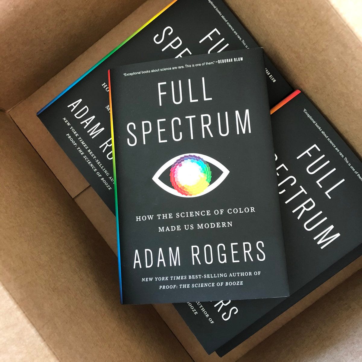 foto van een doos waarin drie exemplaren van het boek Full Spectrum liggen van Adam Rogers. 