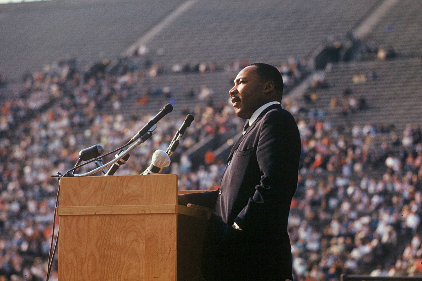 MLK standing a podium in a suit, full color