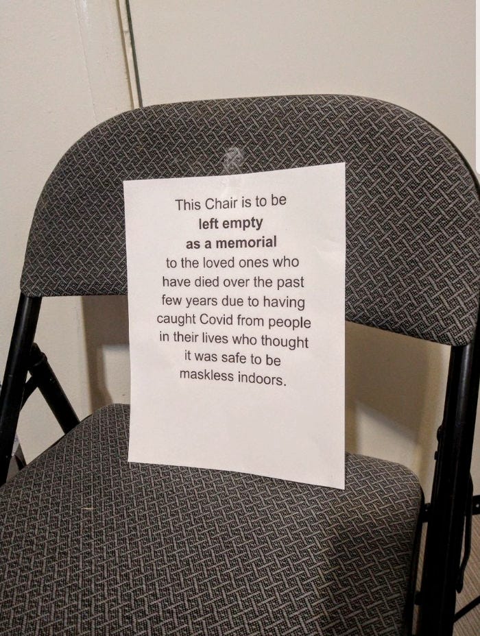 Found on the internet, a photo of a folding chair with a printed page taped to the seat back that says: This Chair is to be left empty as a memorial to the loved ones who have died over the past few years due to having caught Covid from people in their lives who thought it was safe to be maskless indoors.