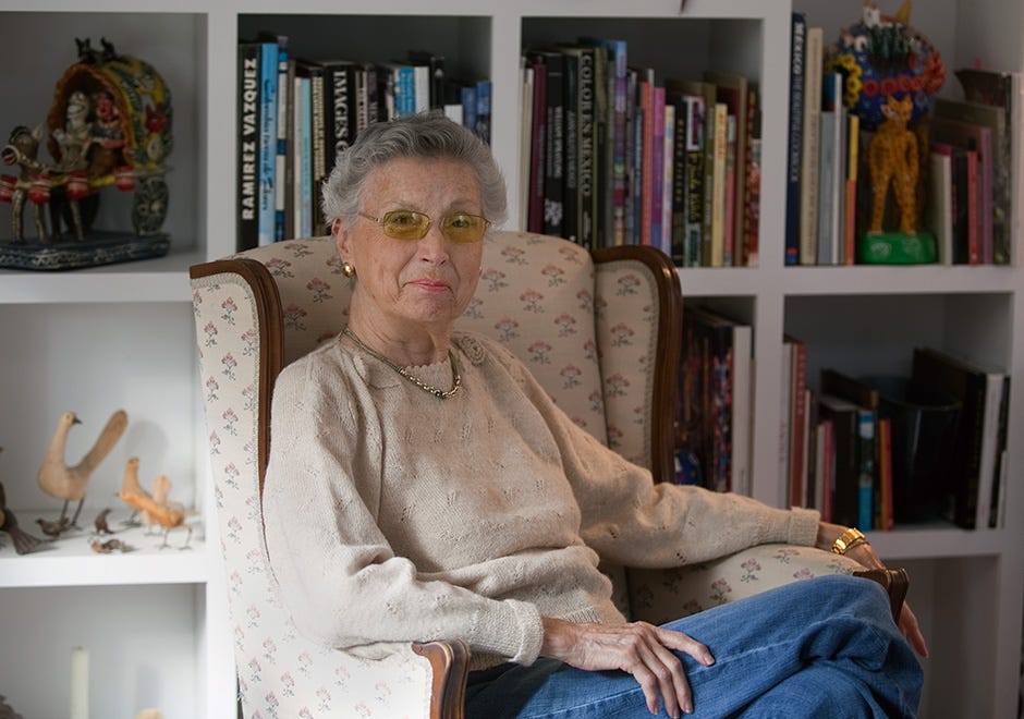 woman sitting in chair in front of bookshelves
