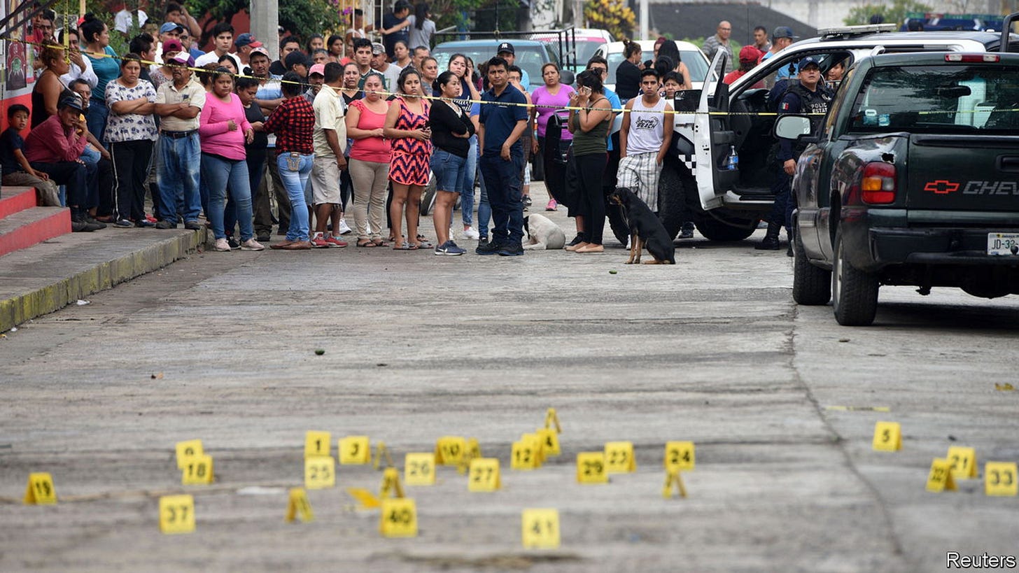 People stand near bullet casings on the ground at a crime scene after a shootout in the municipality Tuzamapan, in the Mexican state of Veracruz, Mexico, May 16, 2019. Picture taken May 16, 2019. REUTERS/Yahir Ceballos - RC1D54952410