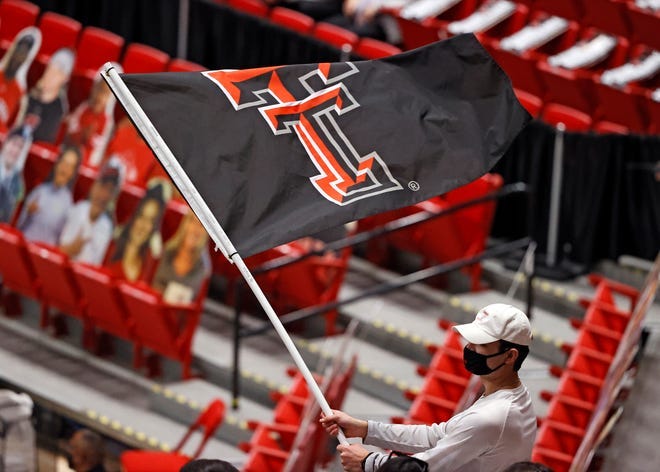 A Texas Tech fan waves a Double T flag during a basketball game last season at United Supermarkets Arena. Tech's trademarks and logos now can be used as part of a group licensing agreement for Tech athletes with The Brandr Group.
