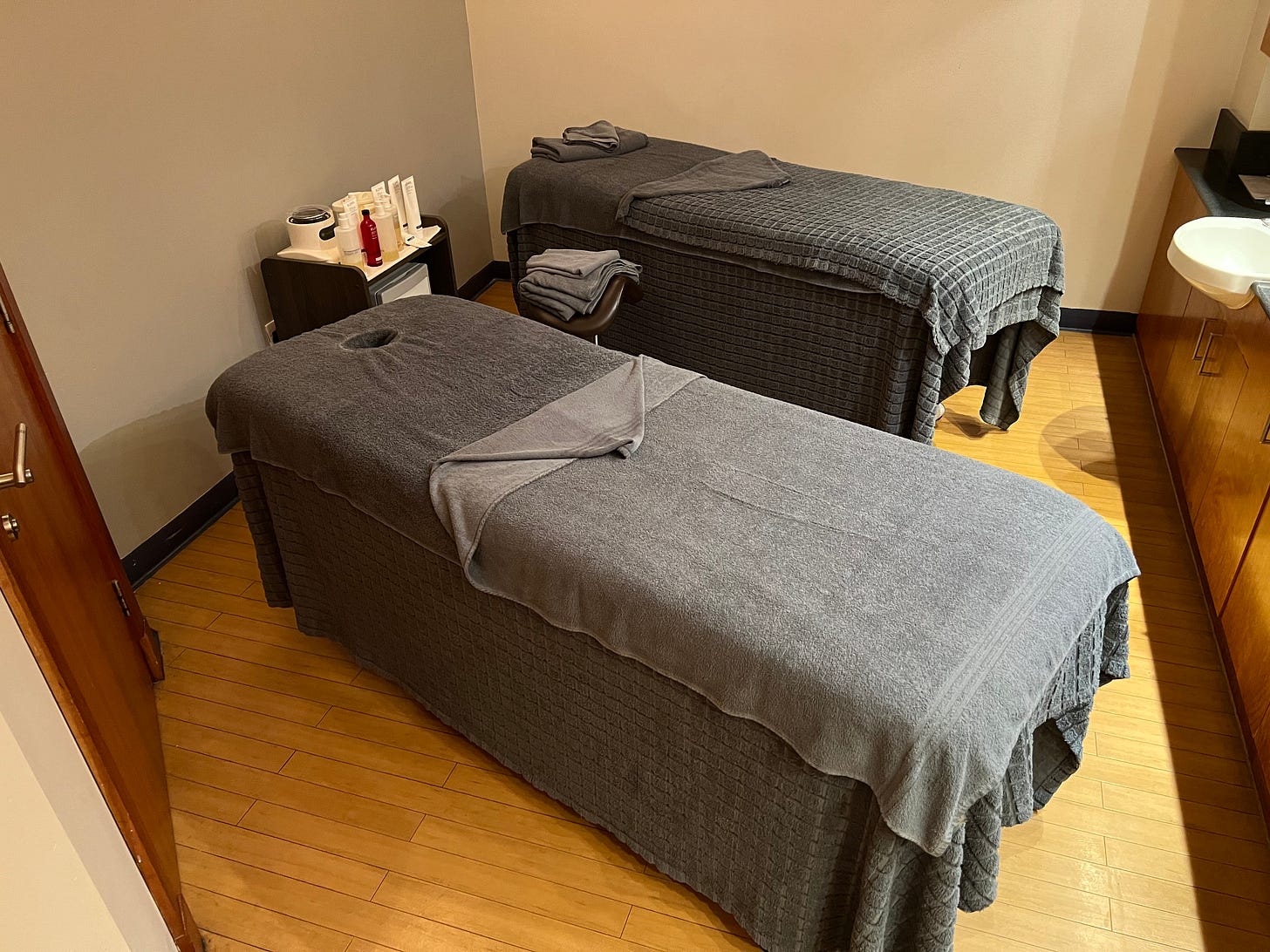 Two massage tables appear in a tidy but small room.