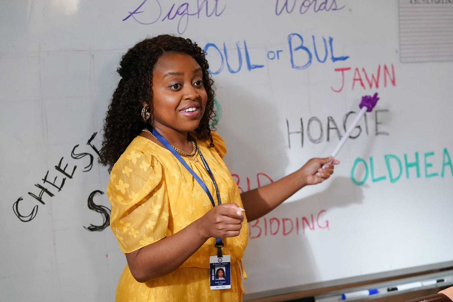 A black woman, played by Quinta Brunson, stands in front of a whiteboard full of Philadelphia slang words like "hoagie" and "jawn"