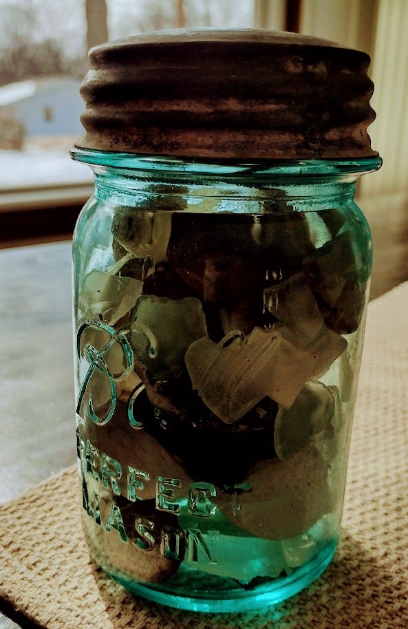 Jar filled with seashells, rocks, and glass fragments Jar filled with seashells, rocks, and glass fragments