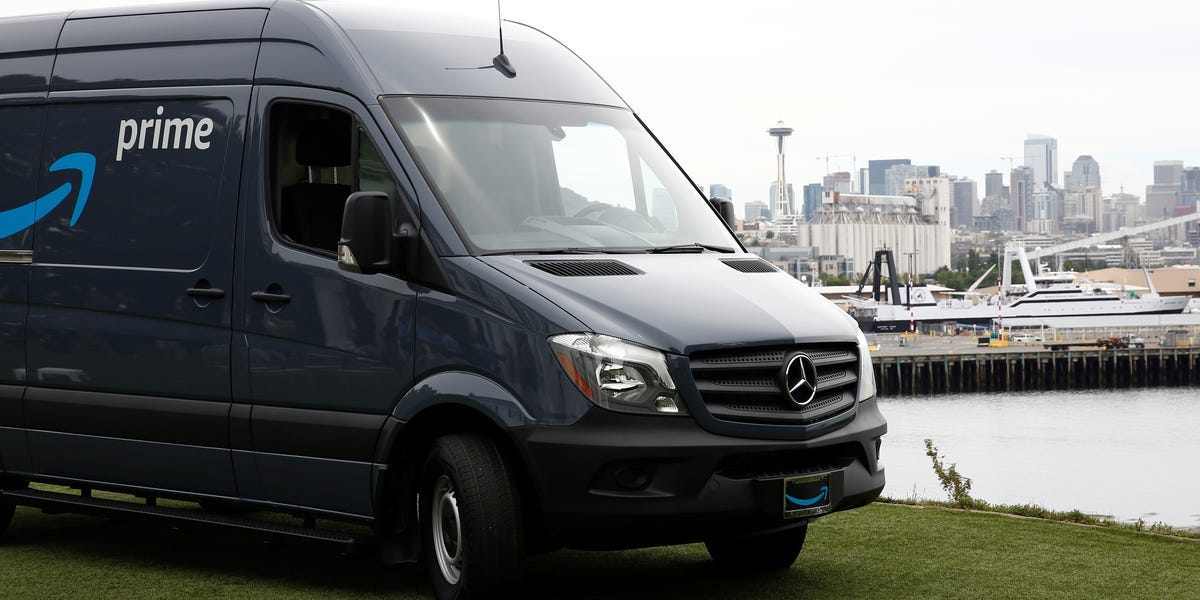 A Prime-logoed gray-blue Mercedes Sprinter delivery van in front of the Seattle Skyline.