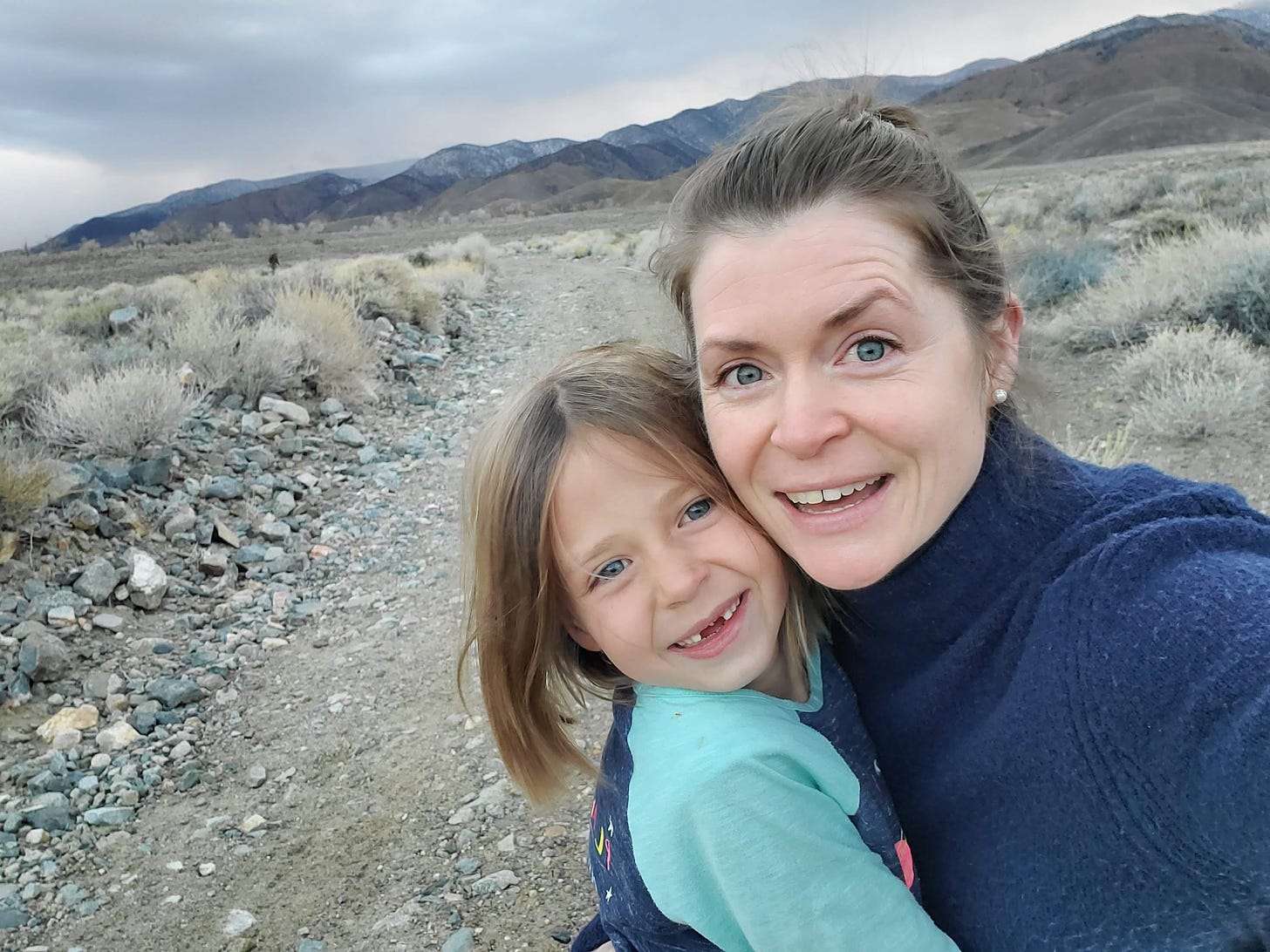 Charlotte and L taking a selfie on a dirt road with White Mountains in background.