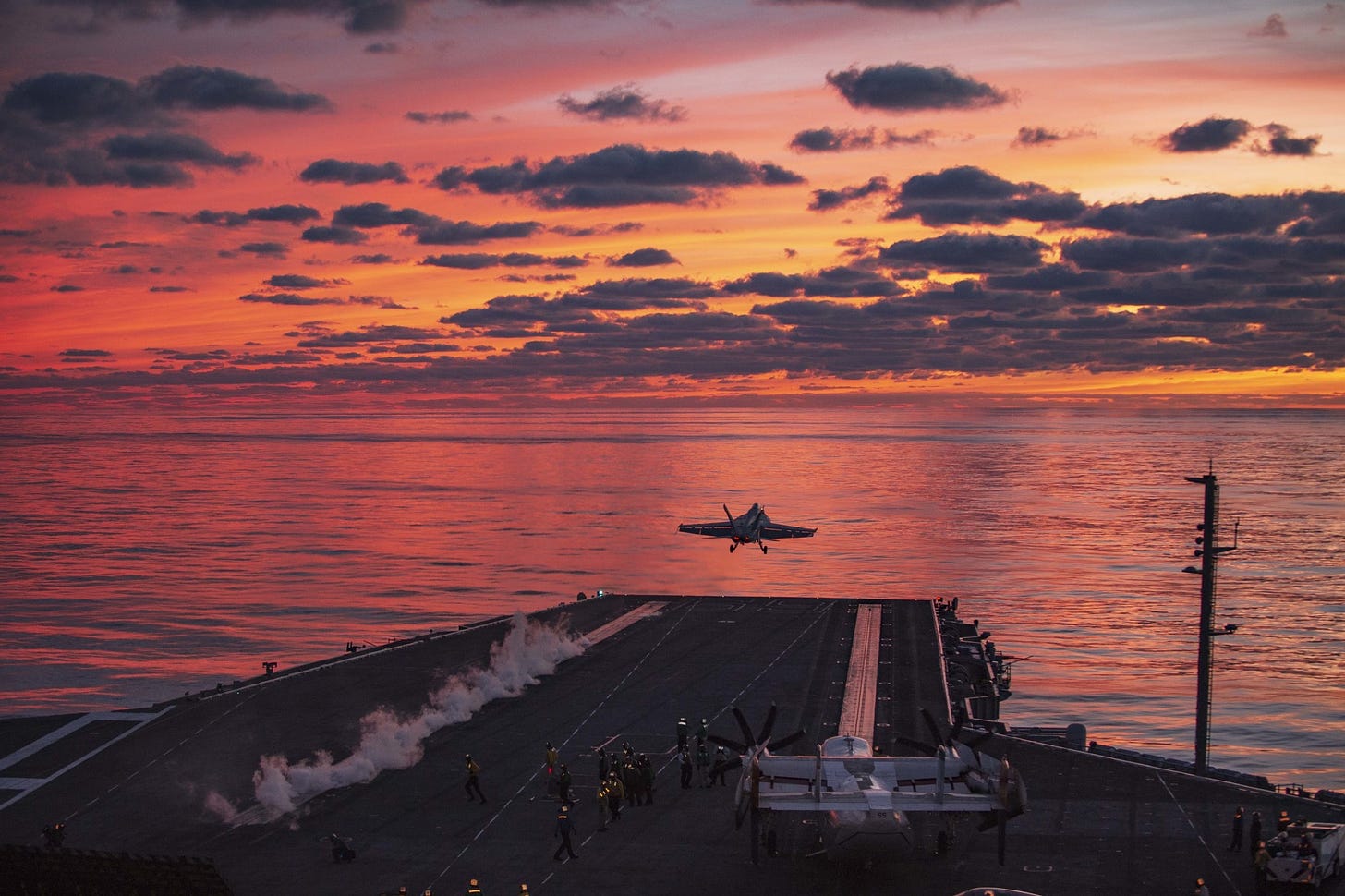 A plane flies off the deck of the Eisenhower carrier, leaving a small trail of steam.