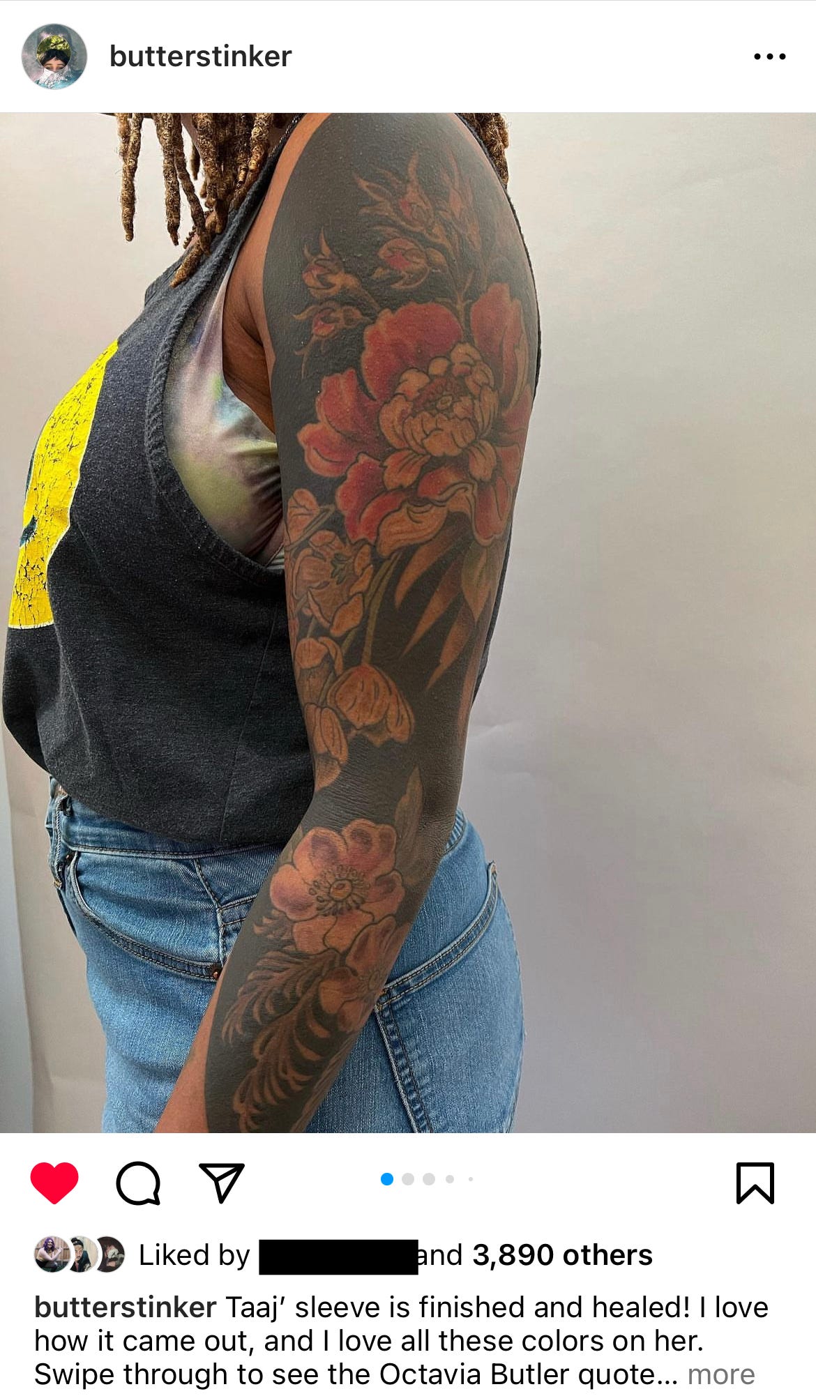 image description: the work of tattoo artist Esther Garcia, who goes by @butterstinker. The image depicts a Black woman with a full tattoo sleeve with a mix of botanical and blackout elements in colour.