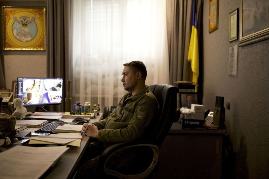 A profile of a man in a military uniform sitting at a desk.