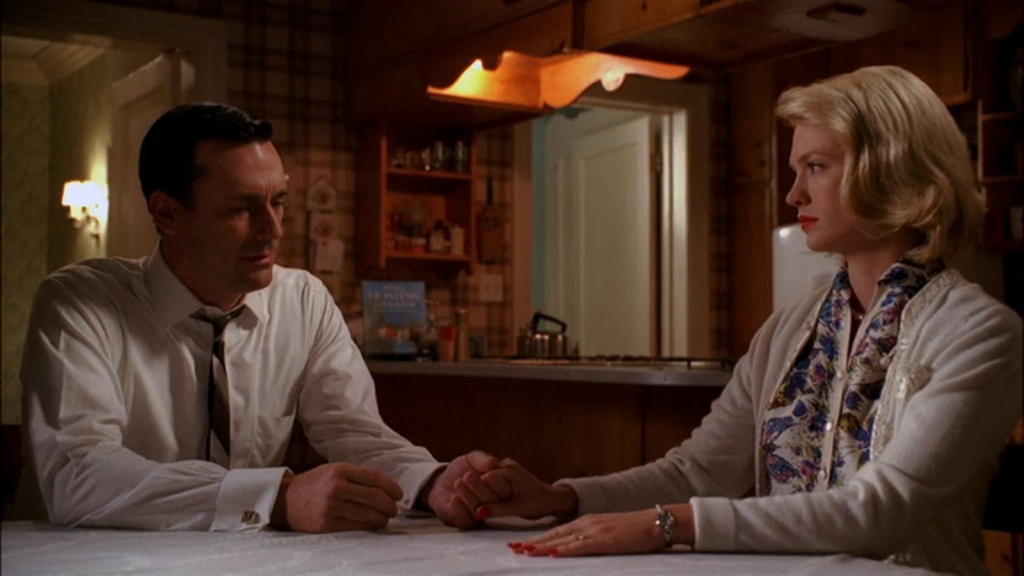 Don and Betty (Jon Hamm and January Jones) hold hands in Season 2 Episode 13 of Mad Men, Meditations in an Emergency