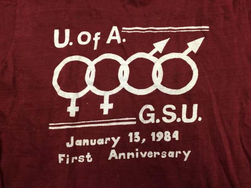 T-shirt del 1984 del University of Alabama Gay Student Union per celebrare il suo primo anniversario. Il GSU, ora Spectrum, è stato il primo gruppo studentesco LGBTQ nello stato dell'Alabama.