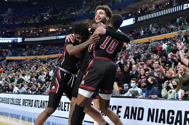New Mexico State Aggies guard Mario McKinney Jr. (4), guard Teddy Allen (0) and guard Sir'Jabari Rice (10) celebrate as the Aggies defeated the Connecticut Huskies 70-63 during the first round of the 2022 NCAA Tournament at KeyBank Center.