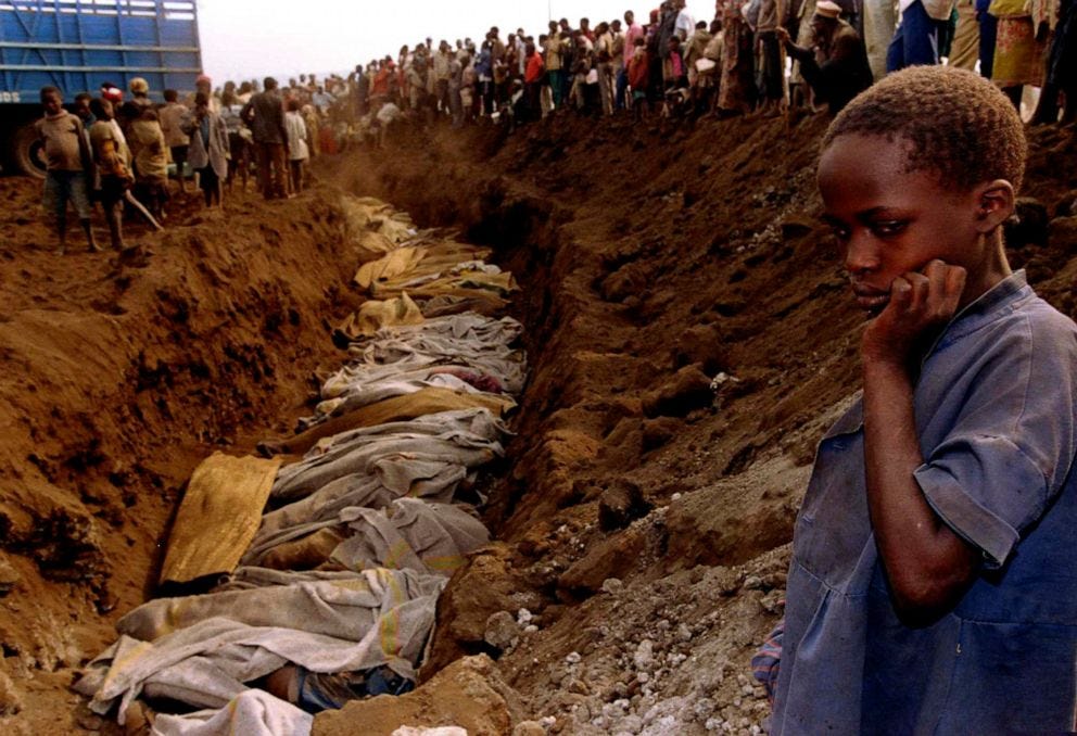 PHOTO: A Rwandan refugee girl stares at a mass grave where dozens of bodies have been laid to rest, July 20, 1994.