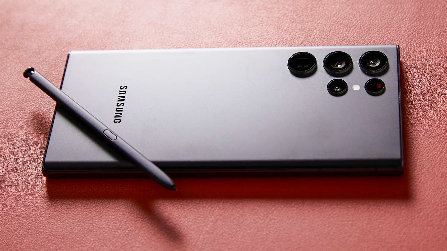 A Samsung Galaxy S22 Ultra with Galaxy S Pen lays on a reddish surface