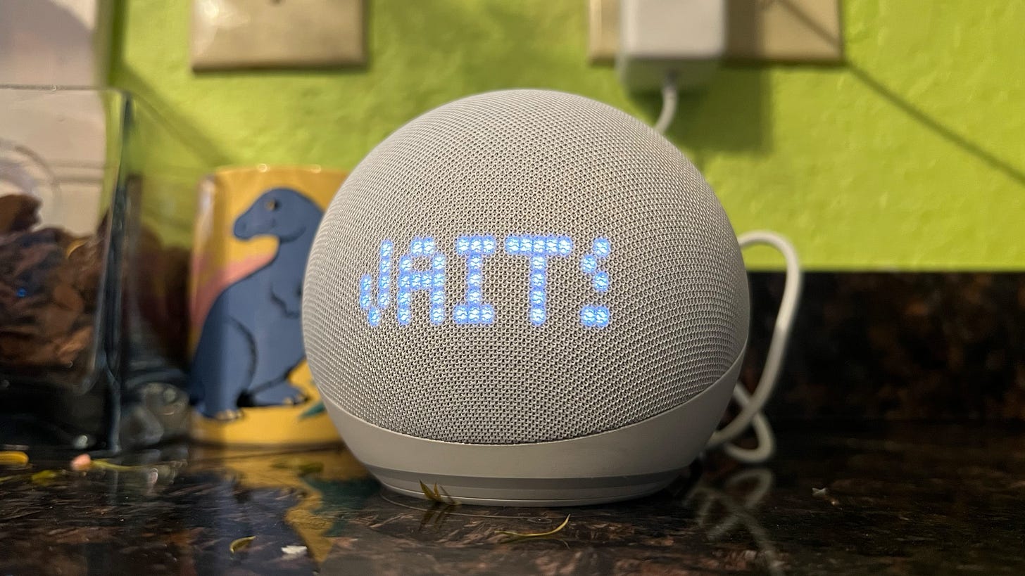 An echo dot with clock scrolls the name of a Tom Waits song while sitting on a countertop