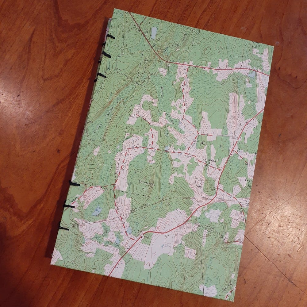 A handmade notebook covered with a mostly green map.