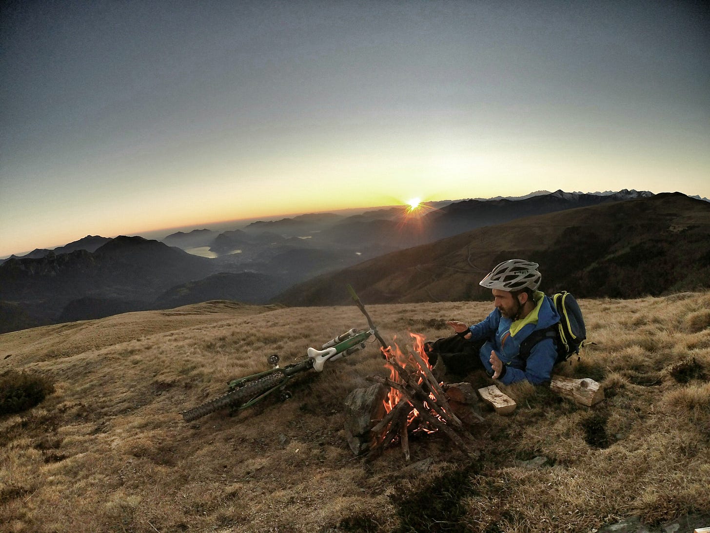 Biker by a campfire in the middle of the wilderness