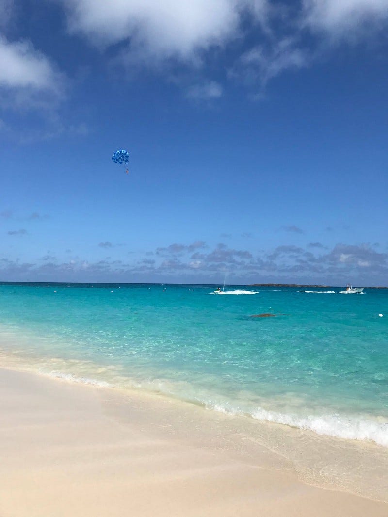 Cove Beach, Paradise Island: Clear ocean, white sandy beach, parasailer in sky
